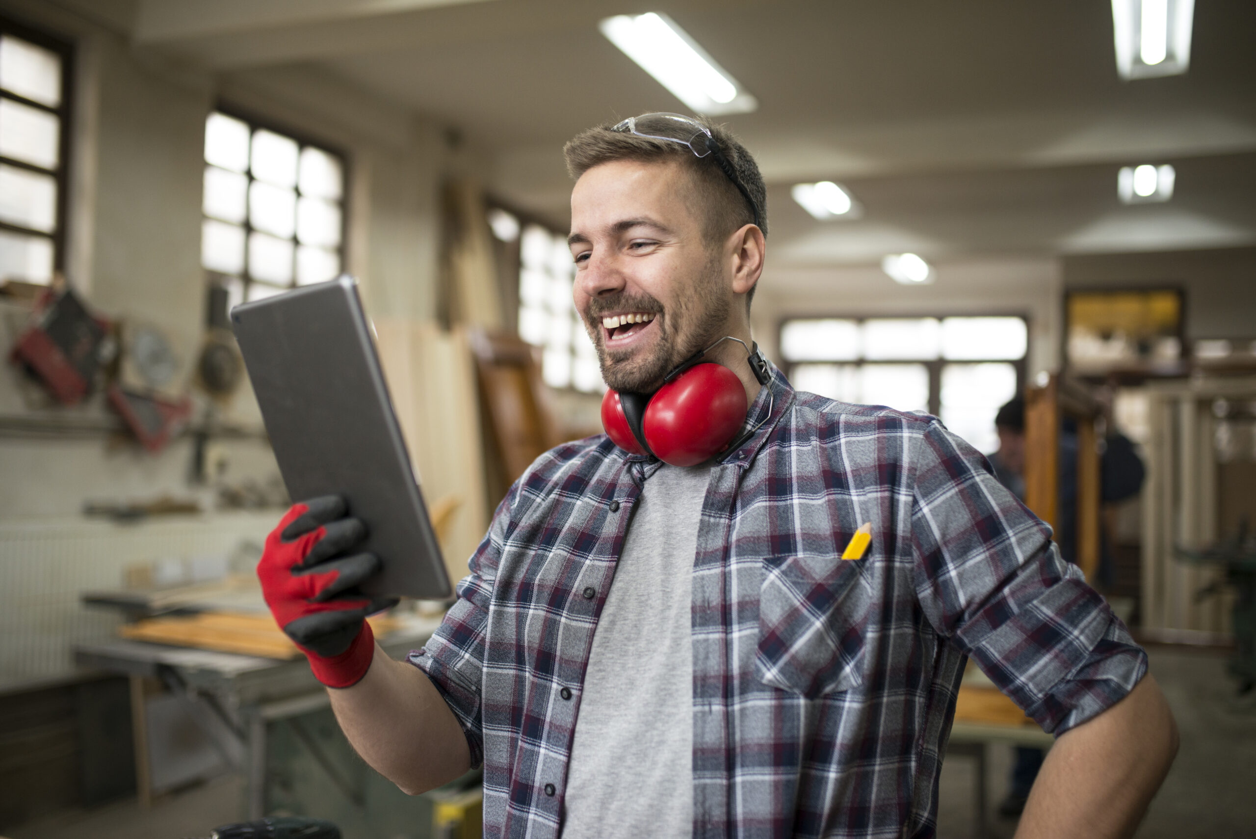 Professional woodworker using tablet in carpentry workshop